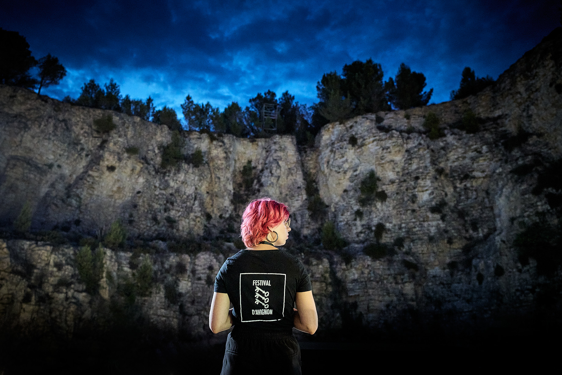 Une personne de l'équipe d'accueil du Festival d'Avignon face à la Carrière de Boulbon.